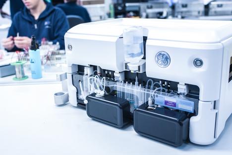 Detailaufnahme eines analytischen Geräts mit Schläuchen und Behältern in einem Labor.