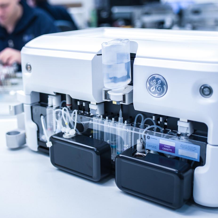 Nahaufnahme eines medizinischen Geräts mit transparenten Schläuchen, Flaschen und Kassette auf einem Tisch.