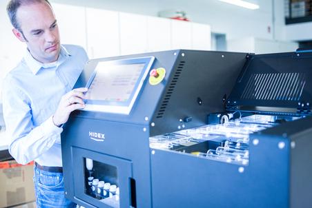 Ein Mann bedient ein HIDEX-Gerät mit touchscreen Anzeige in einem modernen Labor.